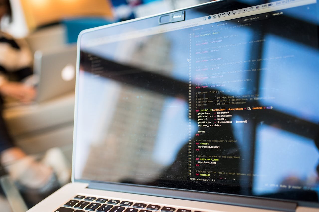 Über uns Laptop displaying code with reflection, perfect for tech and programming themes.