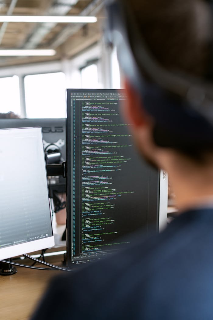 Leistungen A male software engineer working on code in a modern office setting.